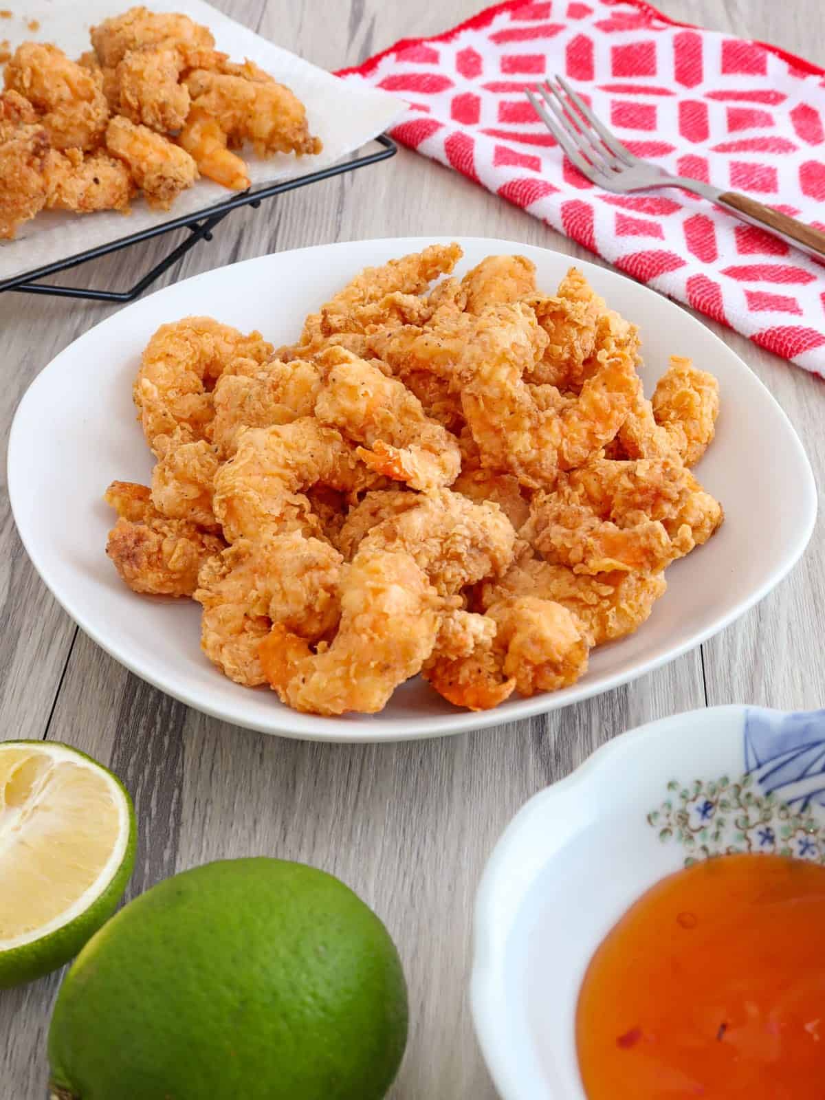 cirspy shrimp in a white serving bowl with a dipping sauce on the side