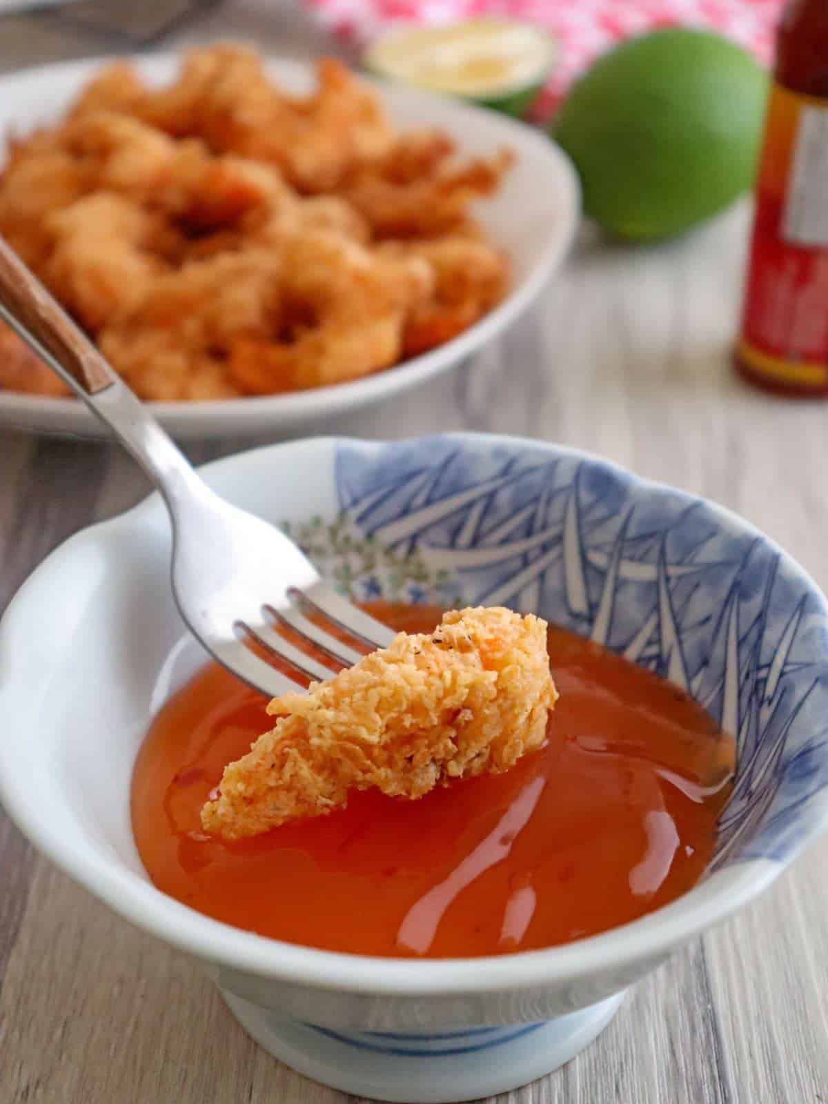dipping fried shrimp in sweet and sour sauce