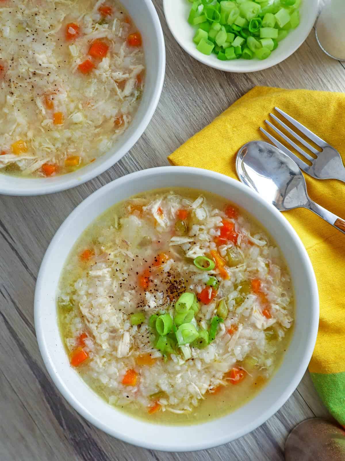 top view of Chicken Rice Congee with green onions in white bowls