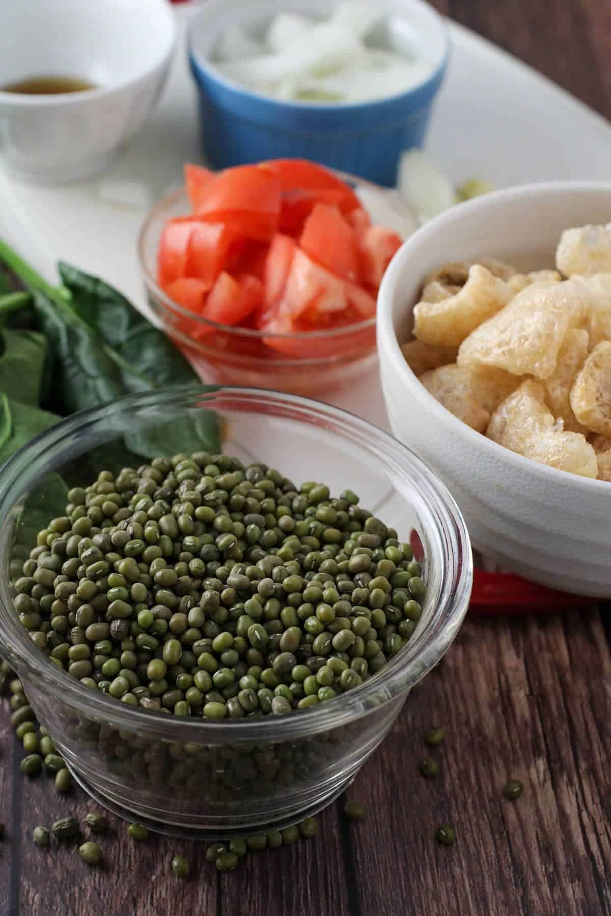 dry mung beans, spinach, chopped tomatoes, pork cracklings, chopped onions, and minced garlic