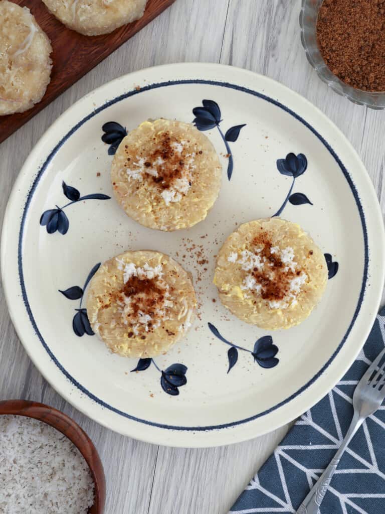 Puto Lanson topped with grated coconut and brown sugar on a plate