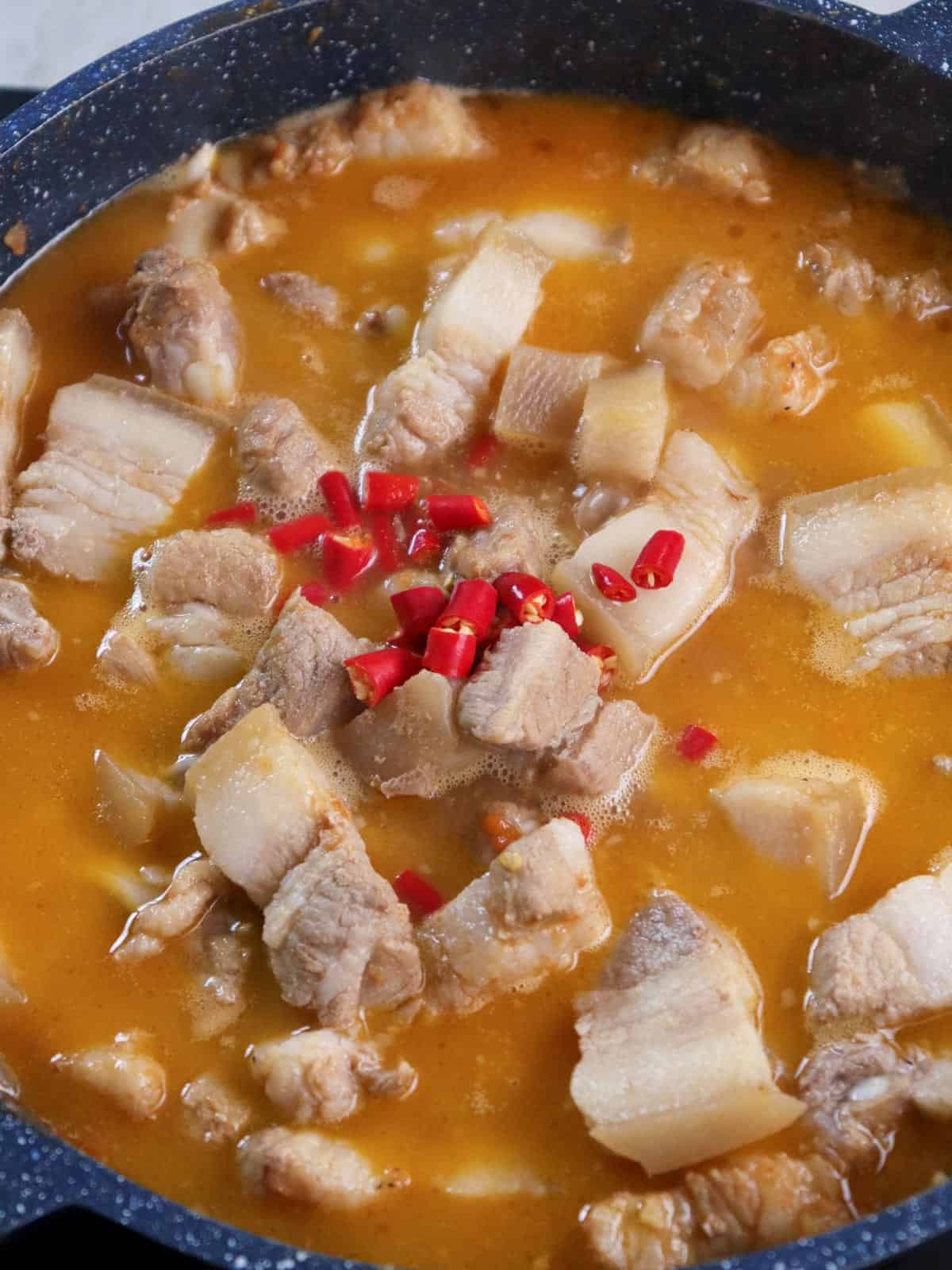 cooking pork binagoongan in a pan