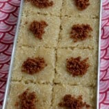 sliced biko in a rectangular pan with latik topping