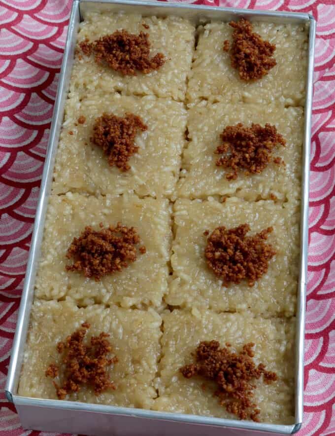 sliced biko in a rectangular pan with latik topping