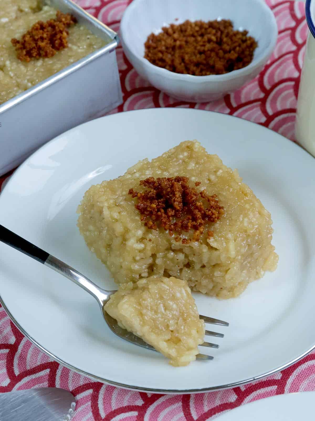 eating sinukmani with a fork on a white plate