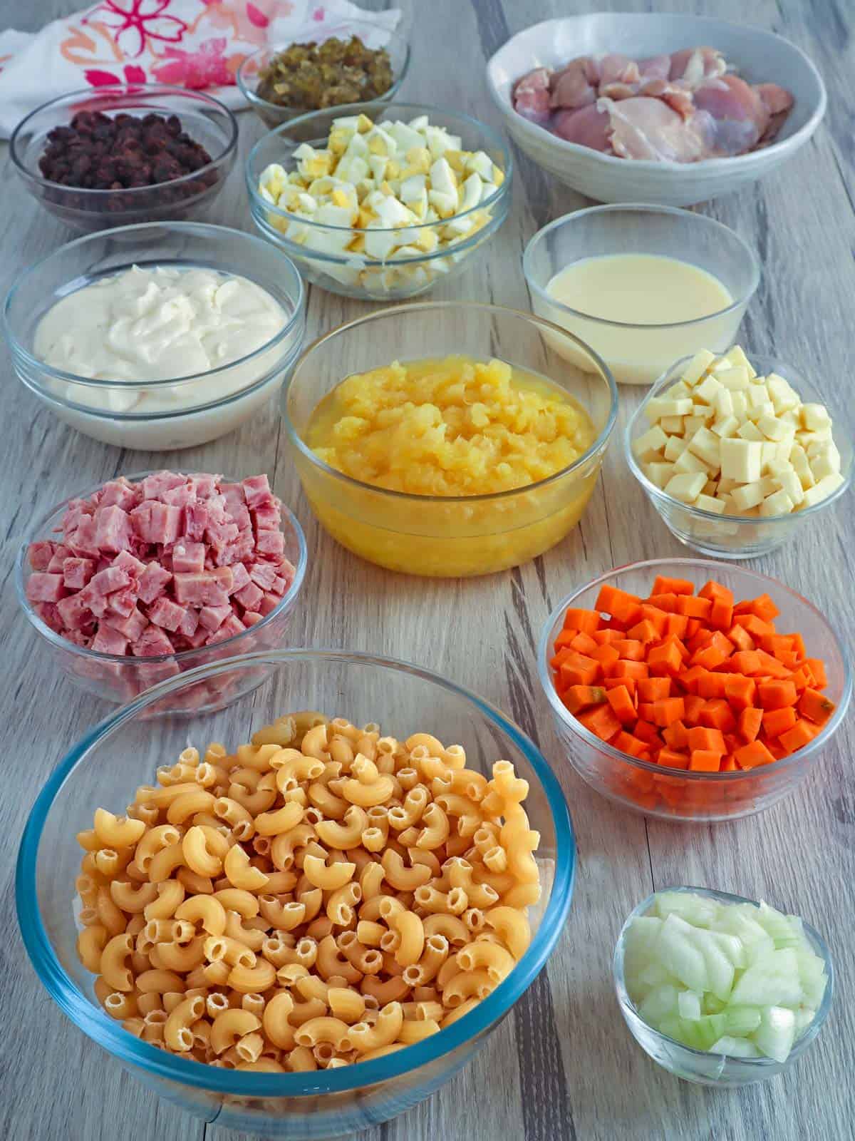 macaroni, diced ham, crushed pineapple, cheese cubes, diced carrots, chopped eggs, mayonnaise, sweet pickle relish, chopped onions, raisins