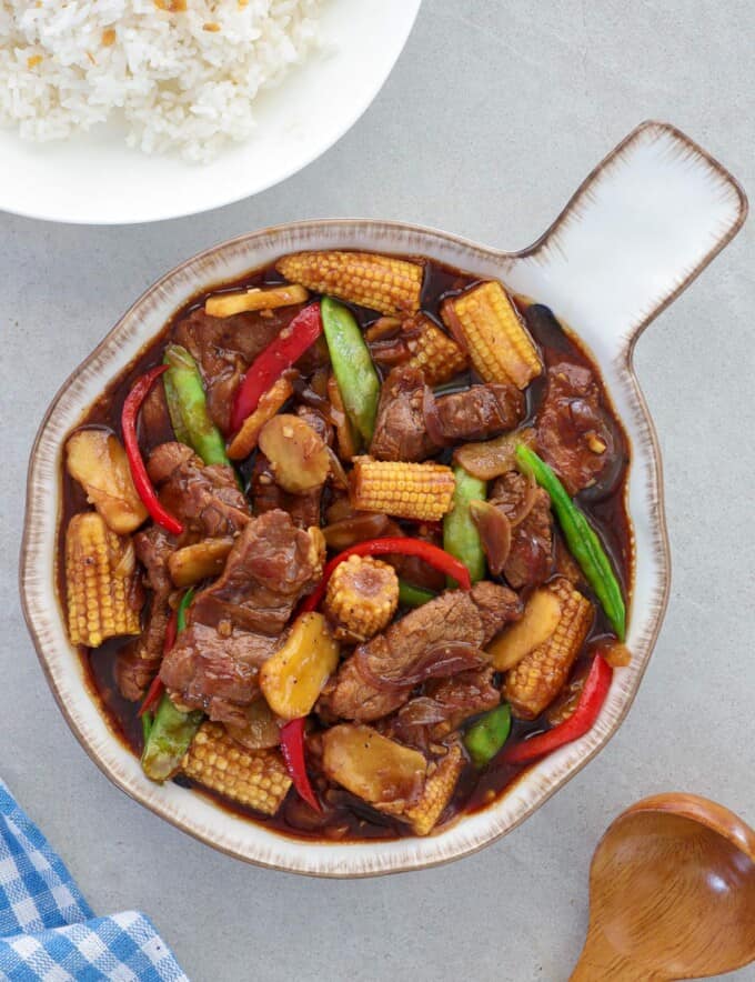 beef and baby corn stir fry in a serving bowl.