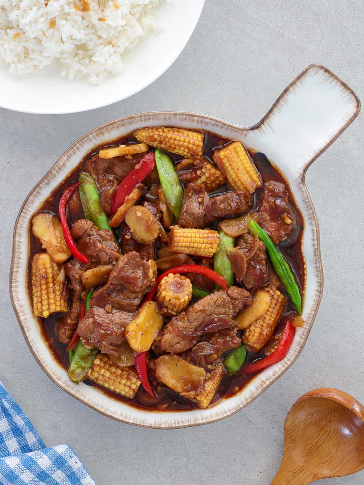 beef and baby corn stir fry in a serving bowl.