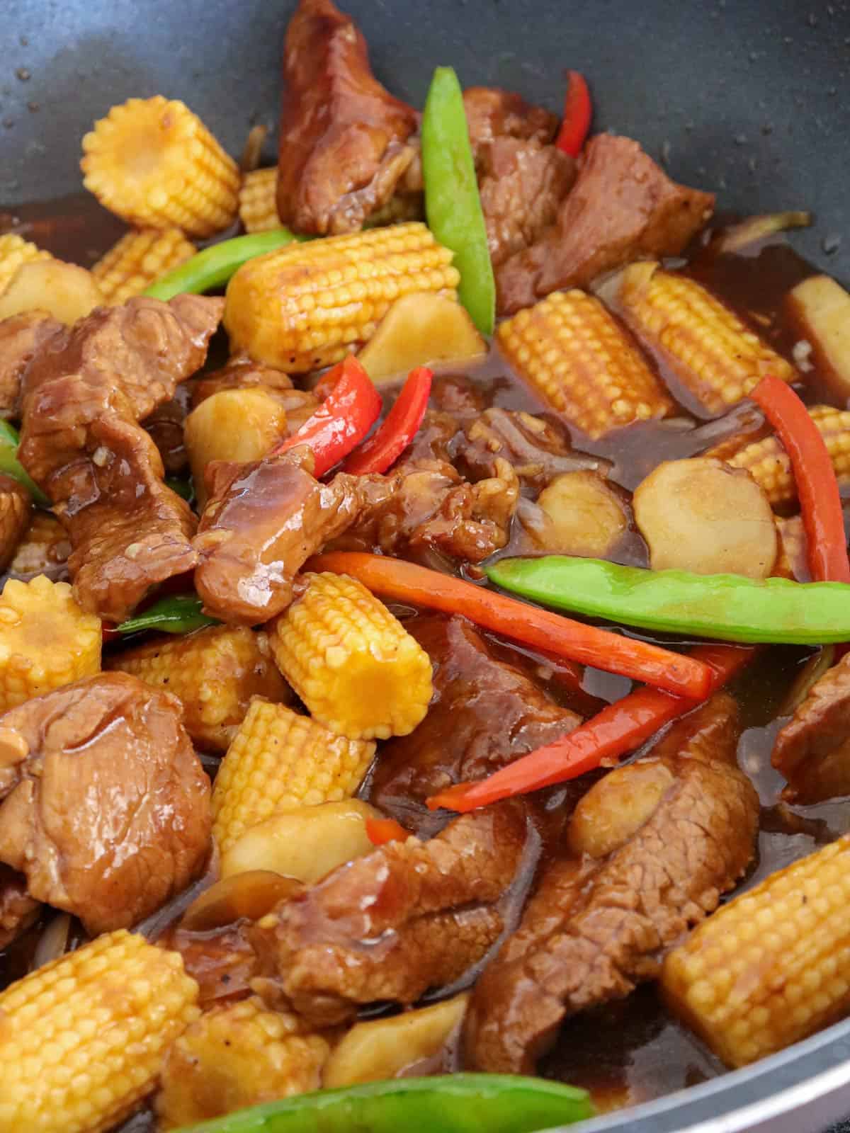 beef stir-fry with veggies in cooked in a pan.