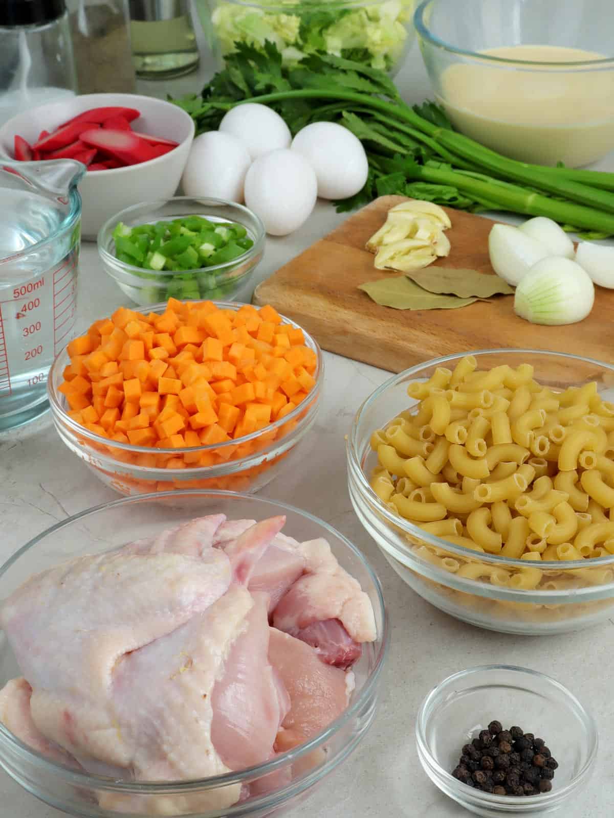 cry macaroni pasta, chicken, celery, diced carrtos, eggs, water, hot dogs, garlic, onions, bay leaves, evaporated milk
