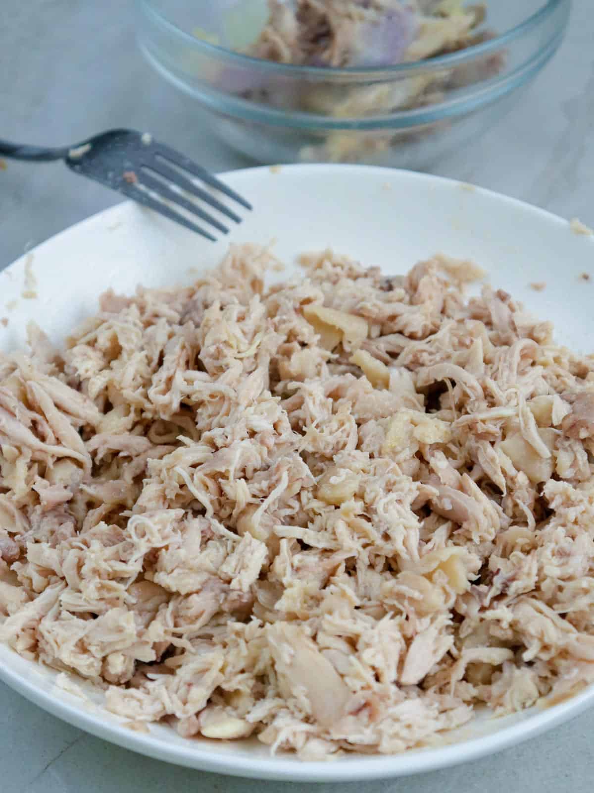 flaked chicken in a white bowl