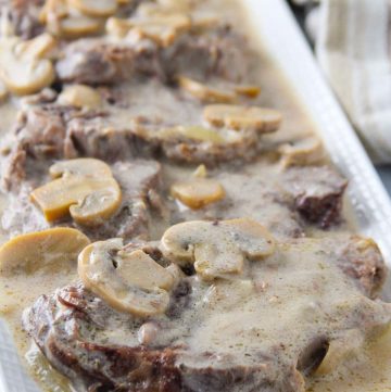 Lengua in Mushroom Sauce on a white serving platter