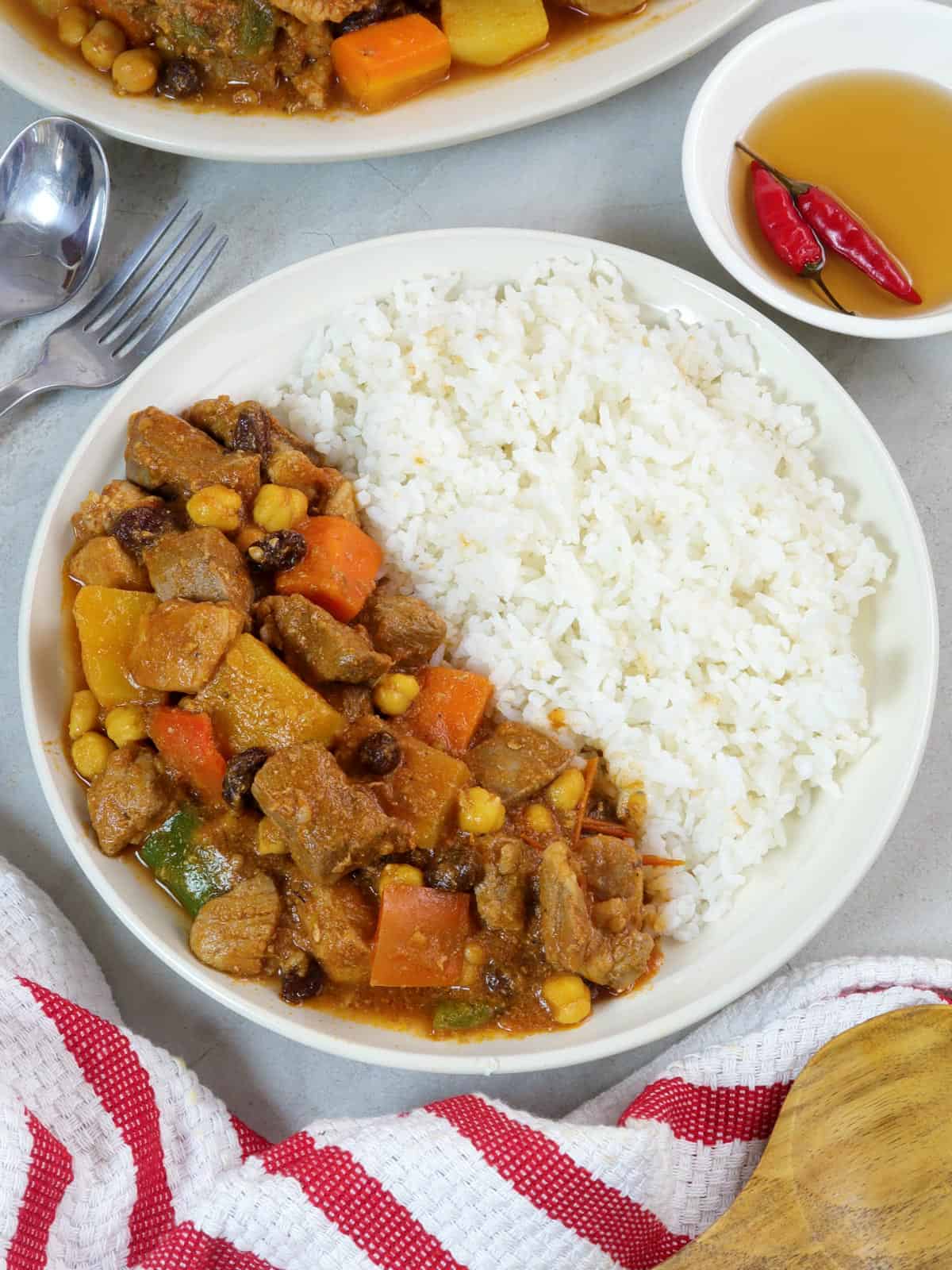 Pork Menudo with steamed rice on a white serving plate