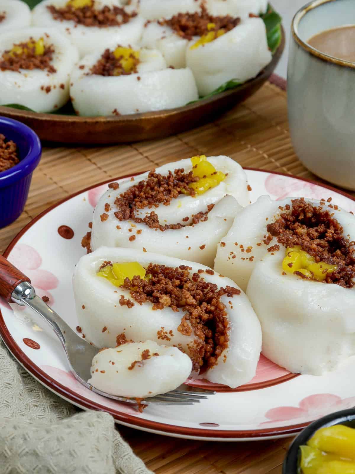 eating sliced kapit on a plate with a fork.