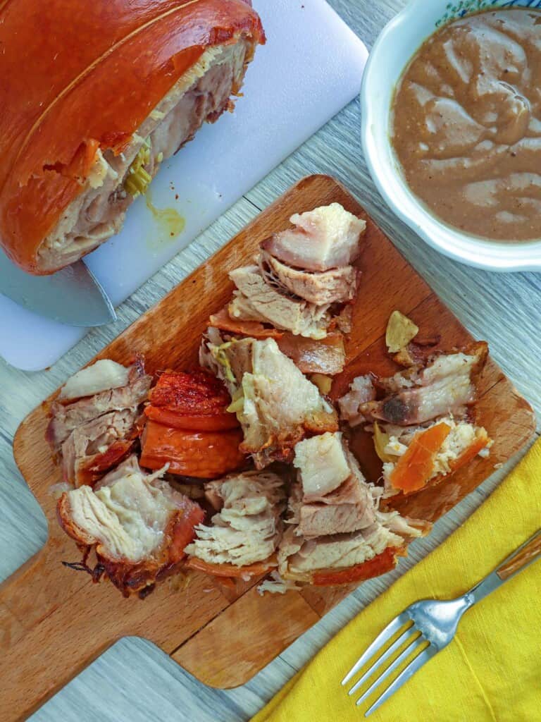 chopped up Pork Belly Lechon Roll on a cutting board