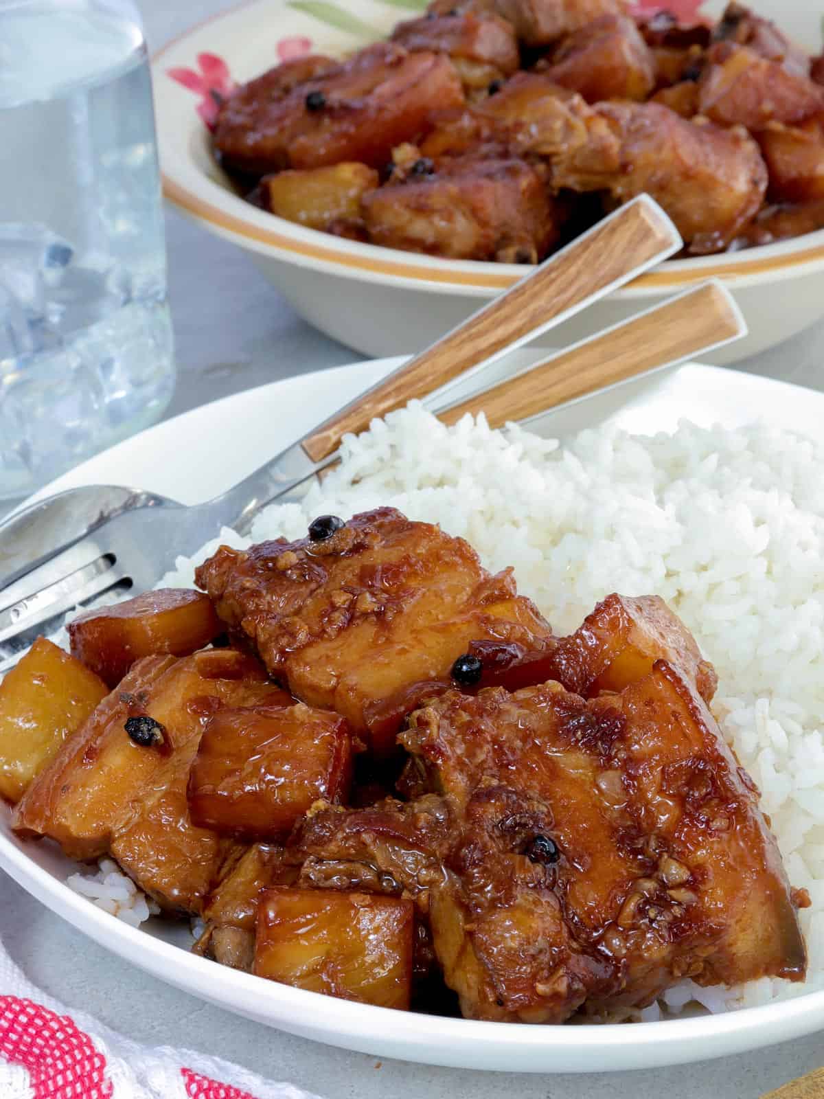 Pork Hamonado on a white serving plate with steamed rice on the side