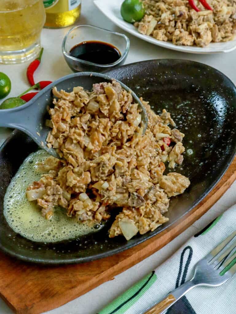 plating Chicken Sisig on a sizzling platter
