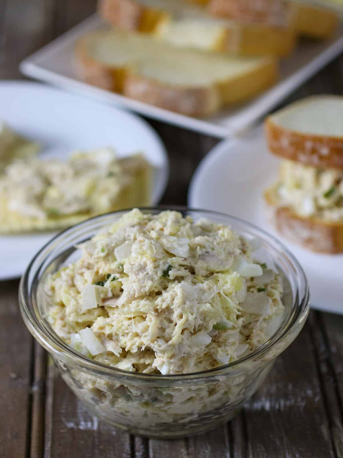 Chicken Salad Sandwich Spread in bowl with sliced bread on the side.