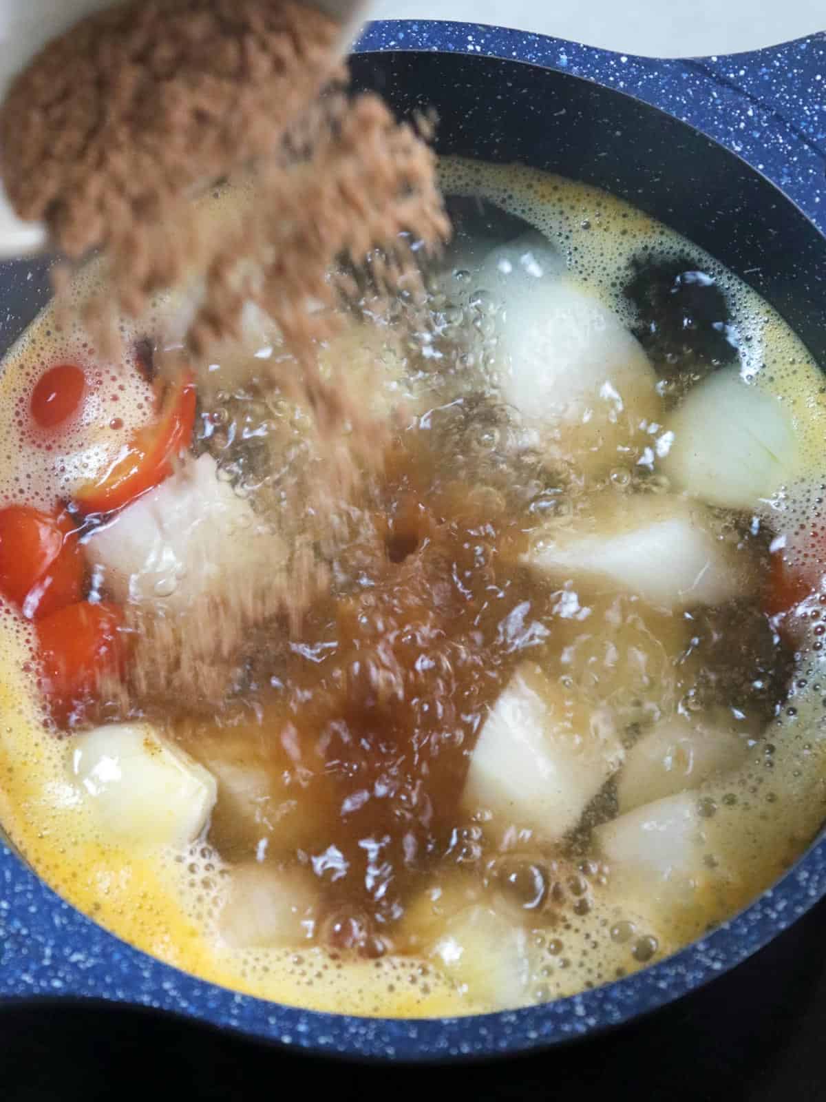 adding tamarind base powder to soup