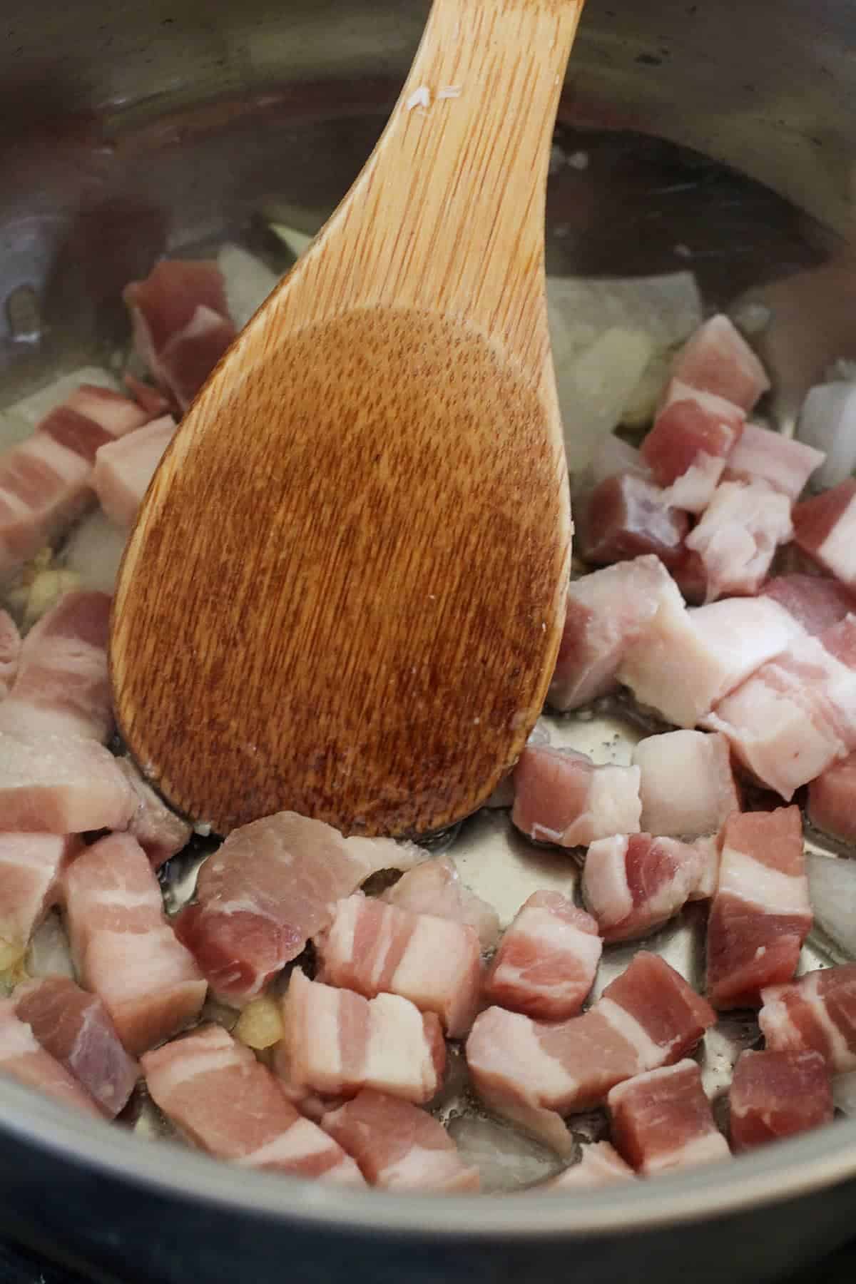 sauteing diced pork belly in wide pan