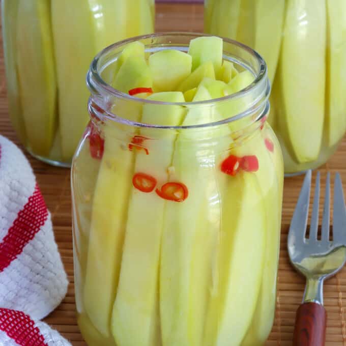 Pickled Mangoes with chili pepper in glass jar