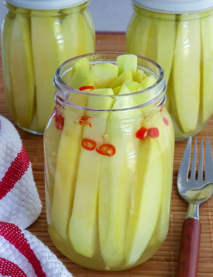 Pickled Mangoes with chili pepper in glass jar