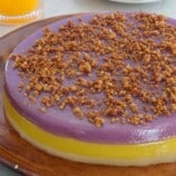 Sapin-Sapin with latik topping on a wooden plate.