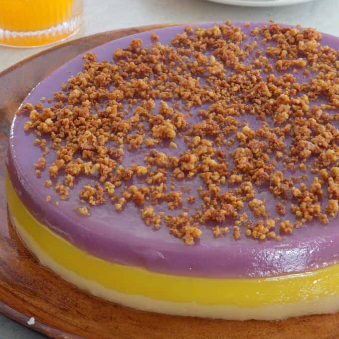 Sapin-Sapin with latik topping on a wooden plate.