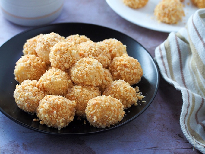 Sticky Rice Balls coated with peanuts on a black plate