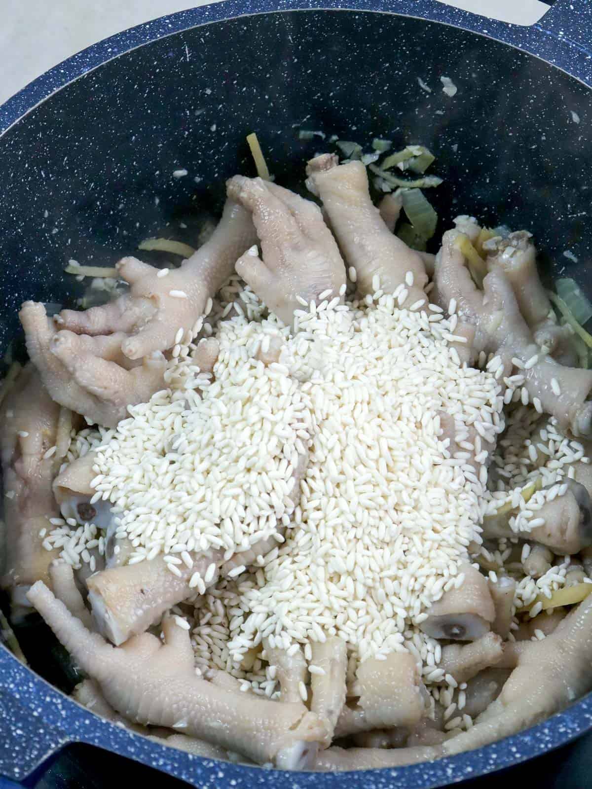 sauteing chicken feet with rice in a pot