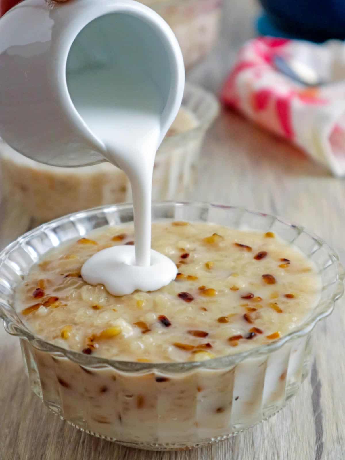 pouring coconut cream on ginataang tutong in a clear bowl