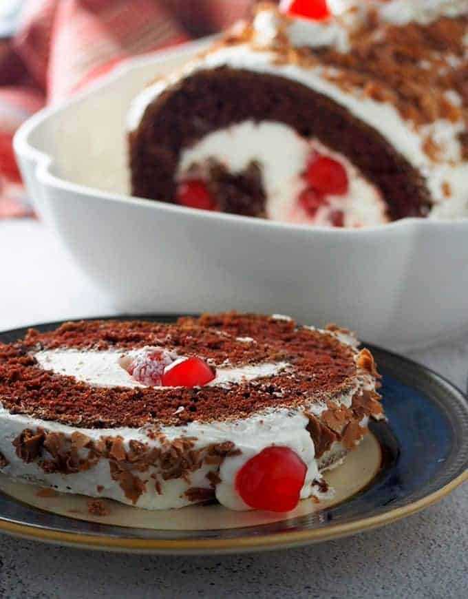 slice of black forest swiss roll cake on a serving plate