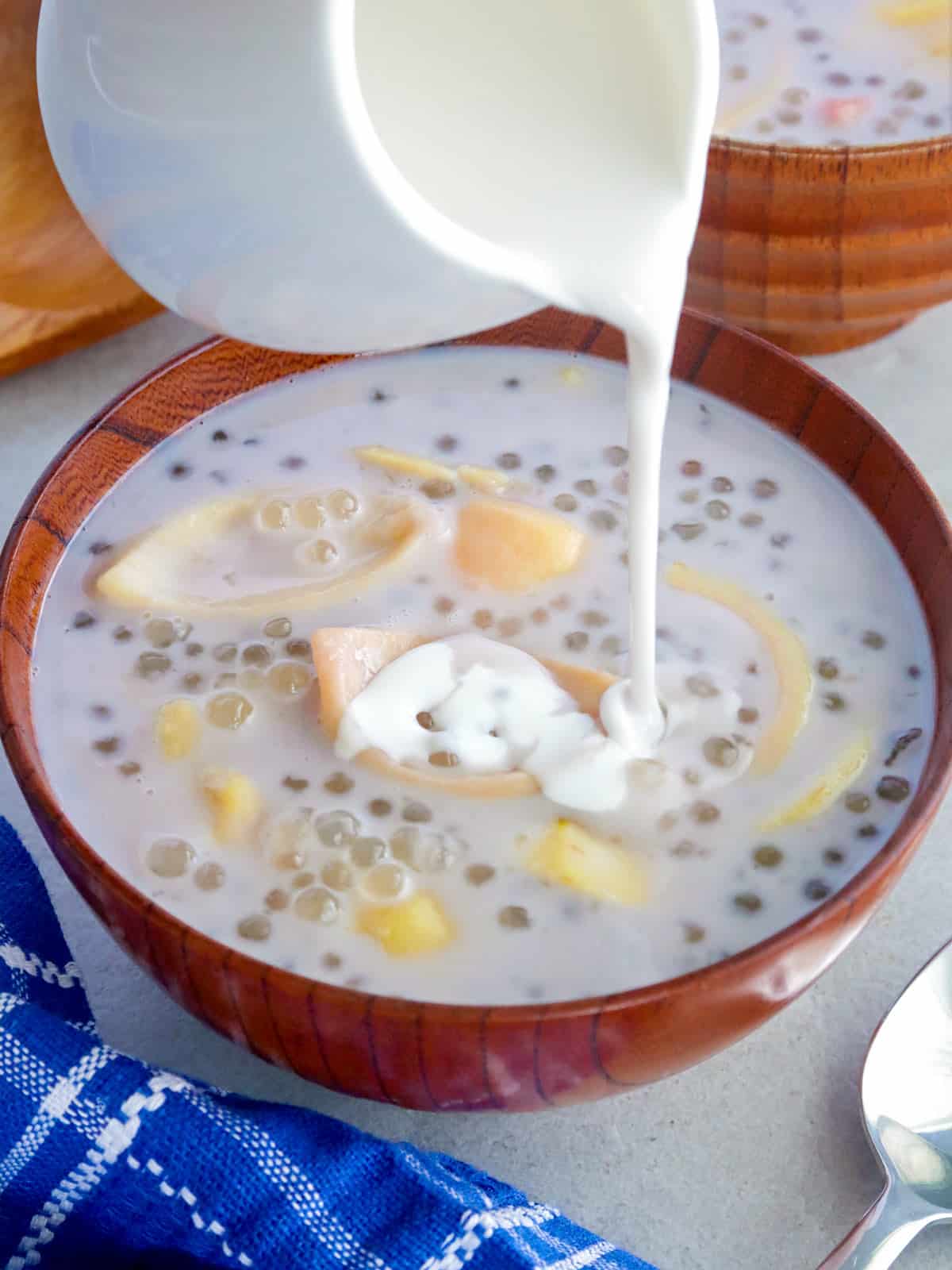 drizzling kakang gata over ginataang guava in a bowl