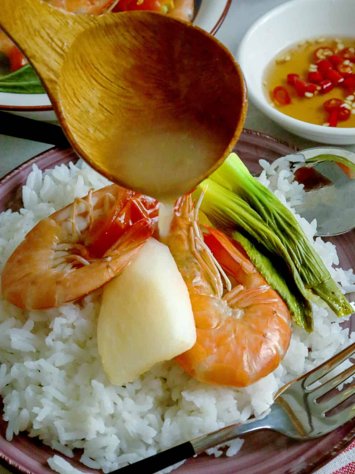 steamed rice with sinigang na hipon on a white plate