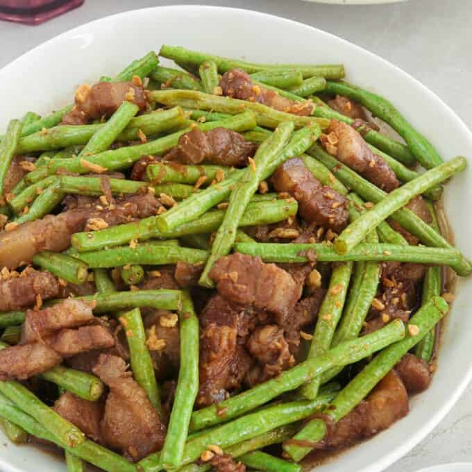 adobong sitaw with pork in a white serving bowl.