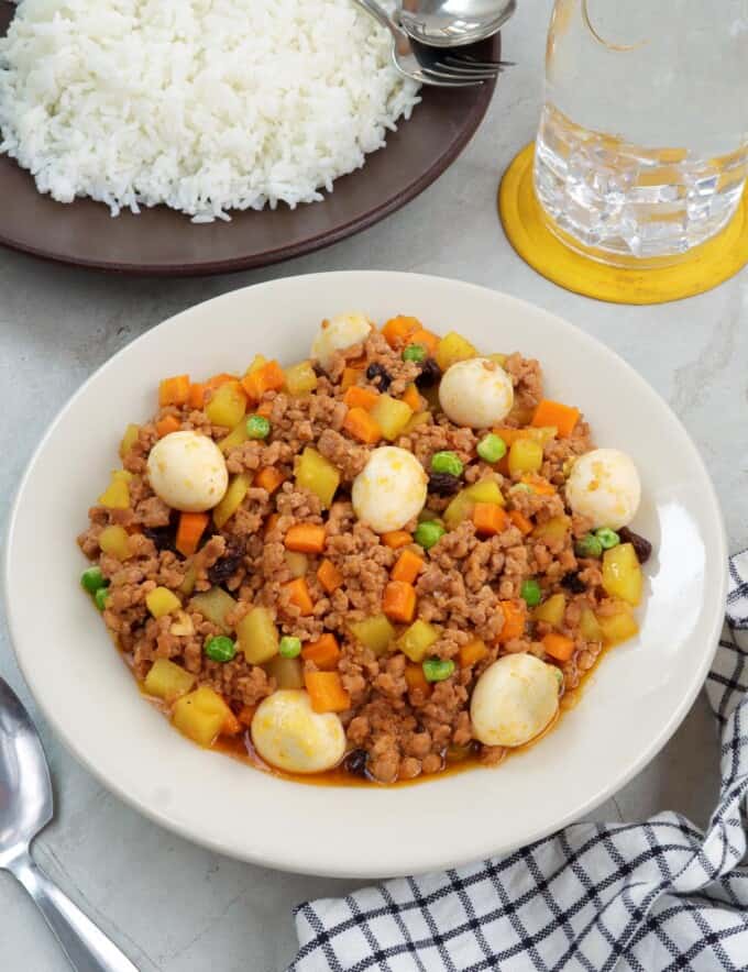 giniling with quail eggs in a white serving bowl