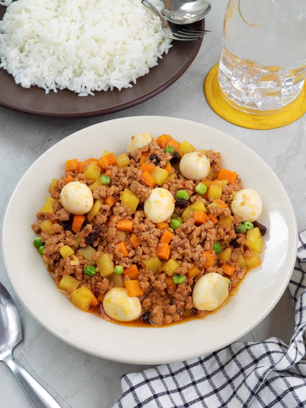 giniling with quail eggs in a white serving bowl