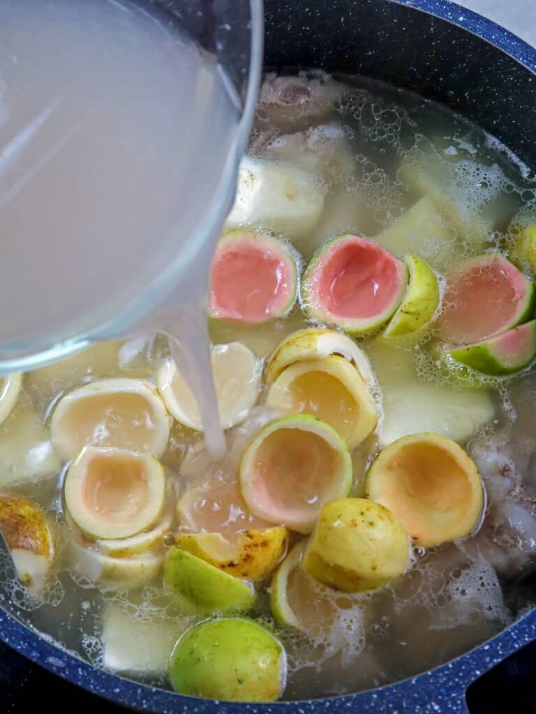 pouring guava juice in a pot of bulanglang