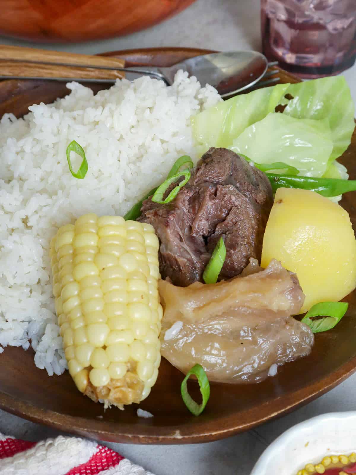 nilagang baka over white steamed rice on a plate