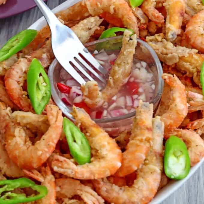 dipping crispy fried drunken shrimp in spicy vinegar