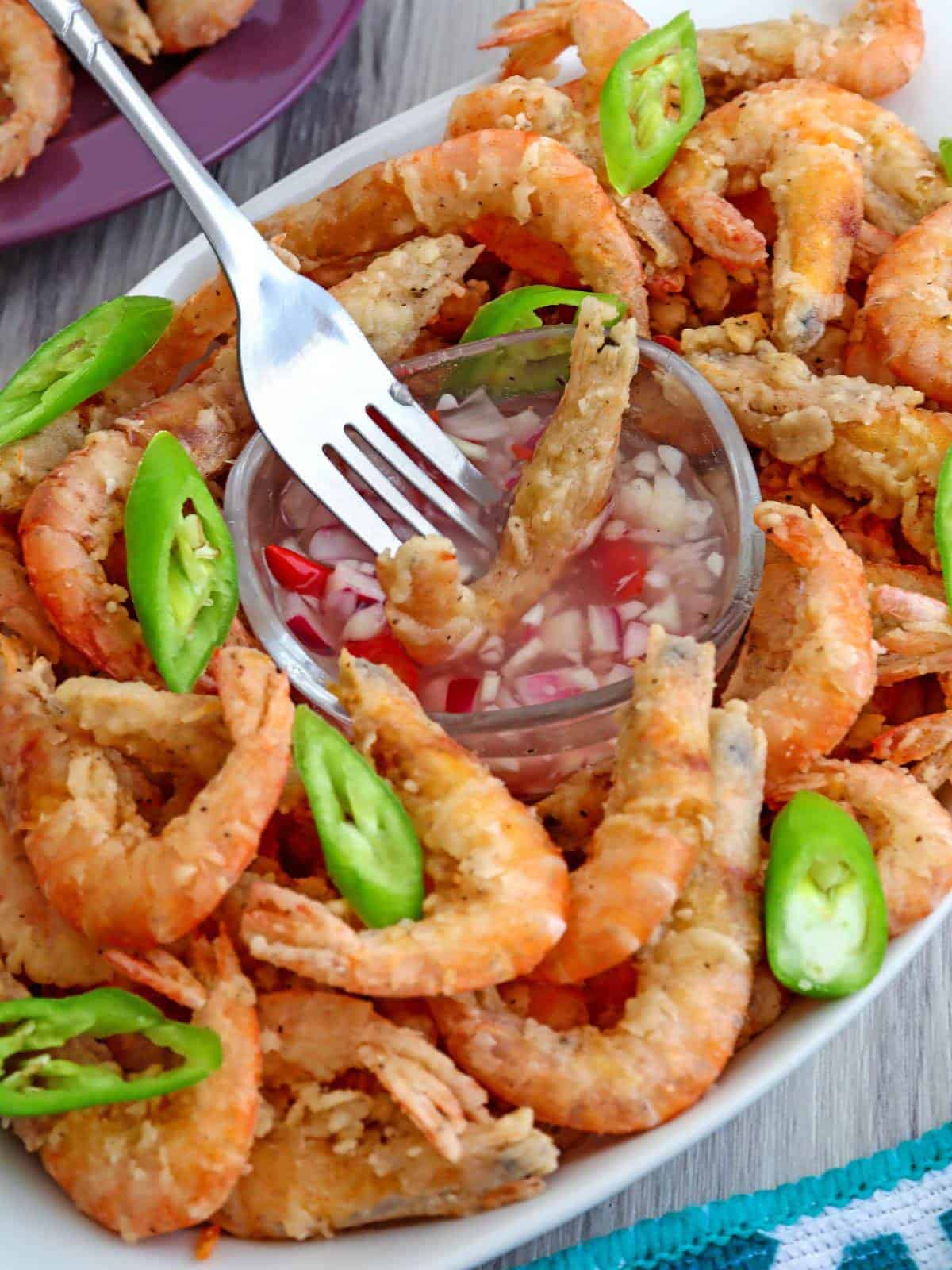 dipping crispy fried drunken shrimp in spicy vinegar