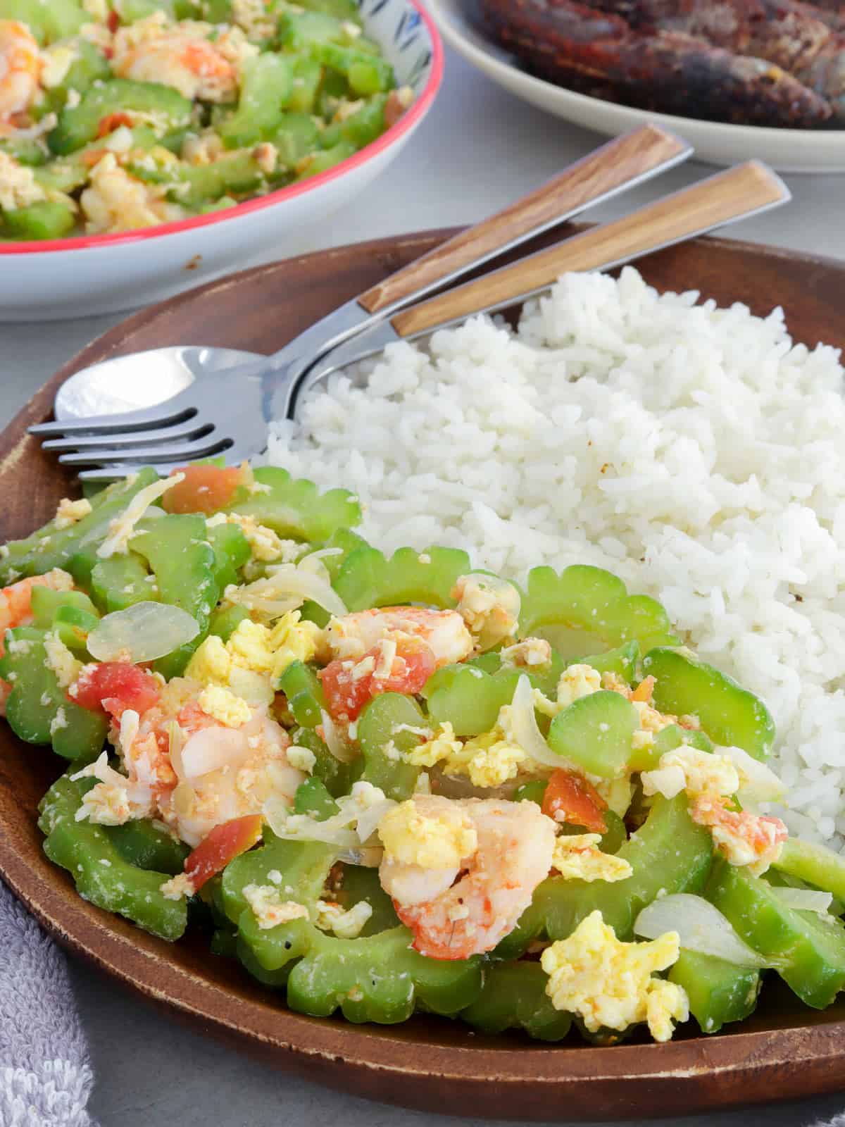 ampalaya stir fry with shrimp on a wooden plate with steamed rice