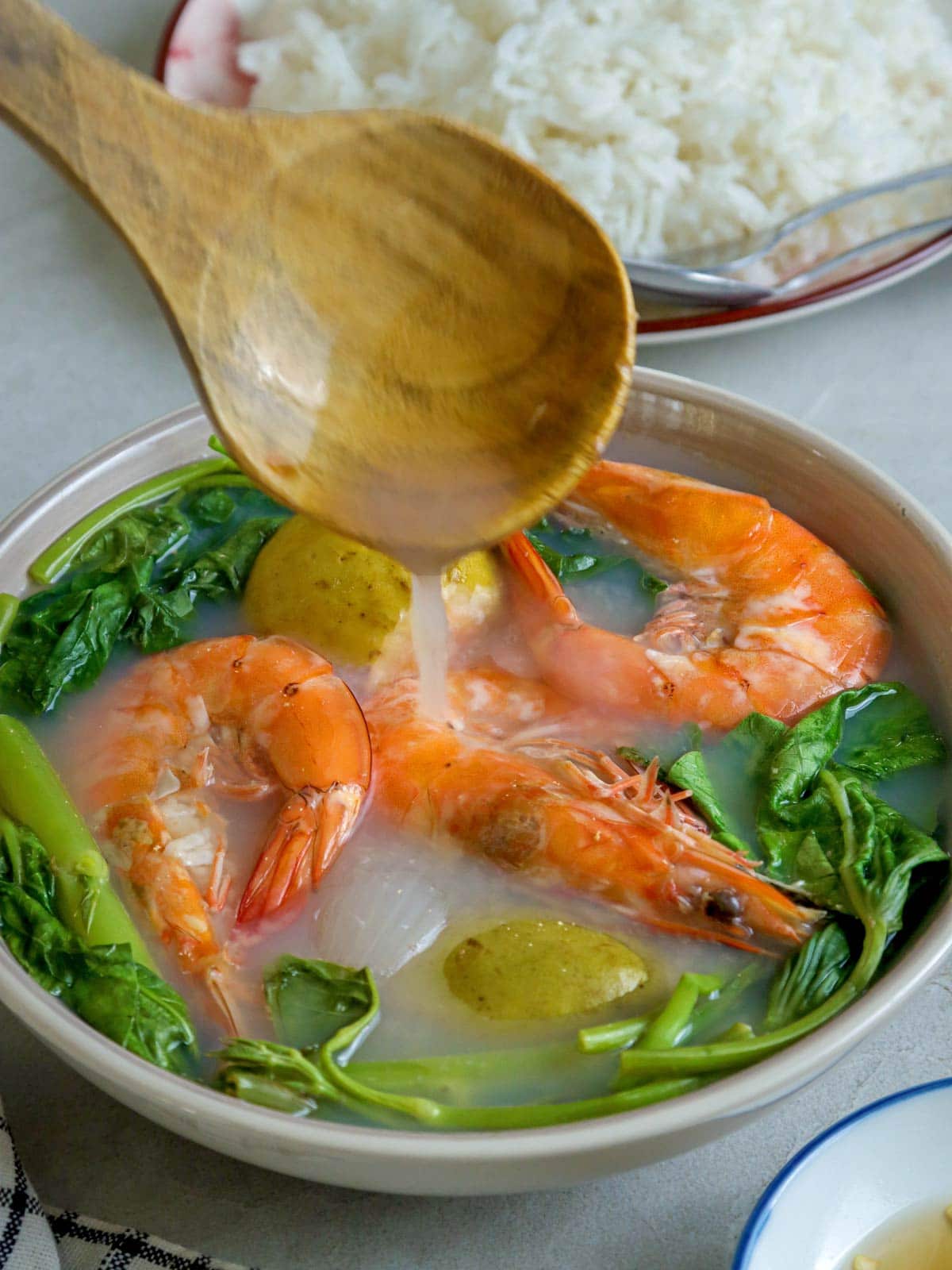 Bulanglang na Hipon in a white serving bowl with a plate of steamed rice and a small bowl of patis on the side