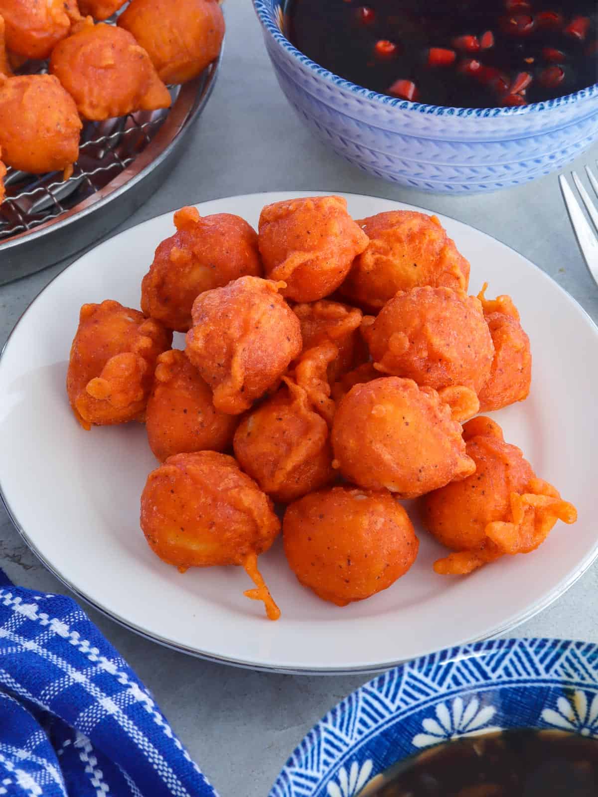 Kwek-kwek on a white plate with dipping sauce