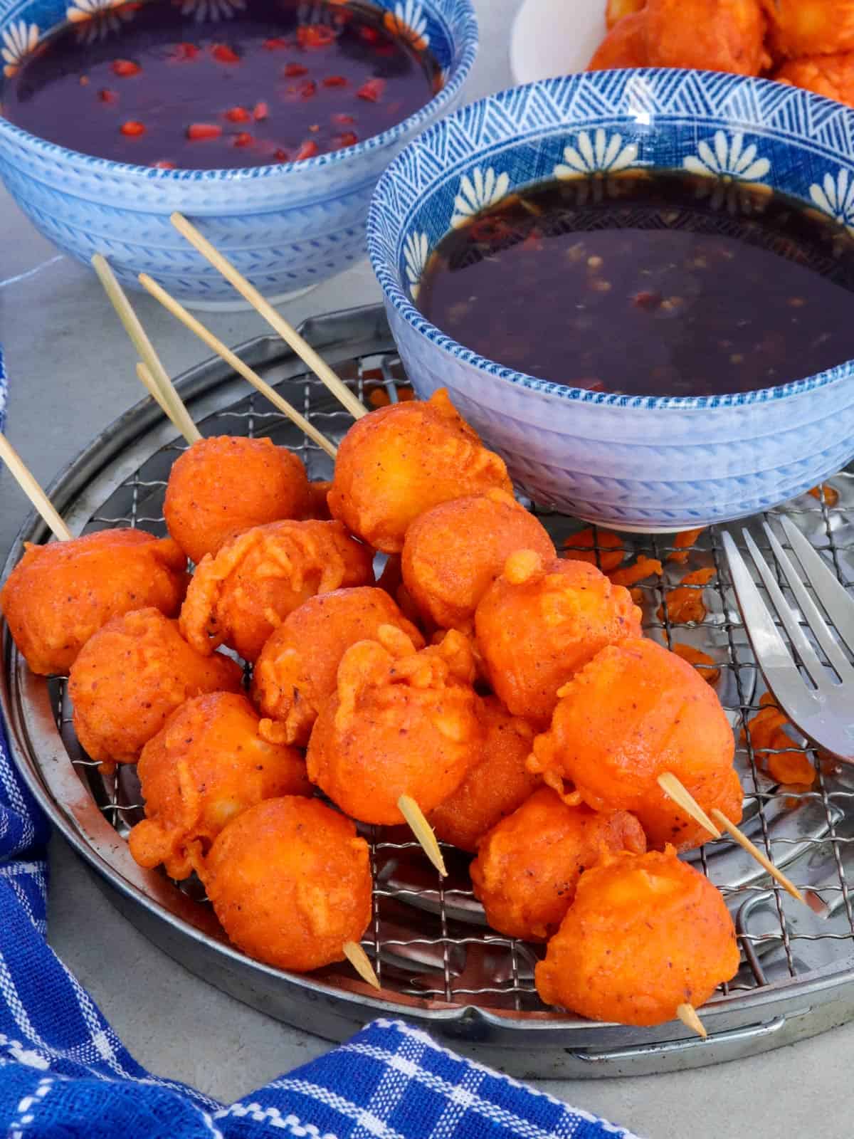 Kwek-Kwek in bamboo skewers with dipping sauce on the side