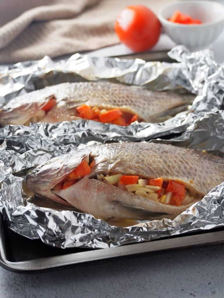 tilapia stuffed with tomatoes and onions and wrapped in foil