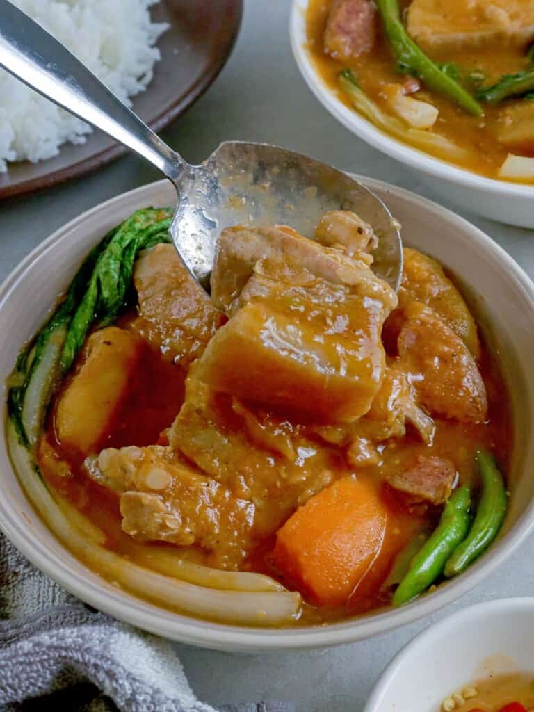 serving pork pochero in a bowl