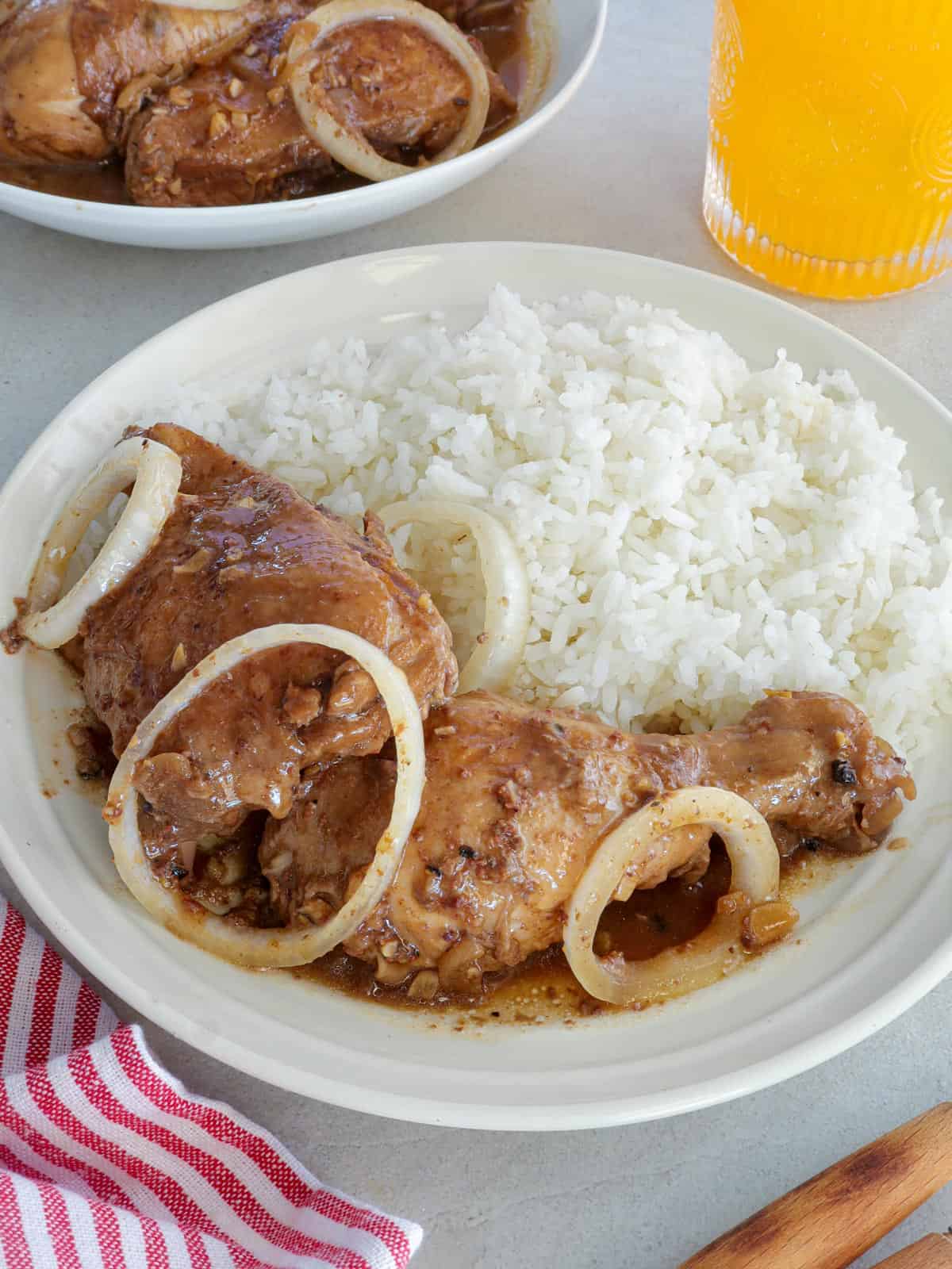 Chicken Bistek with steamed rice on a white plate.