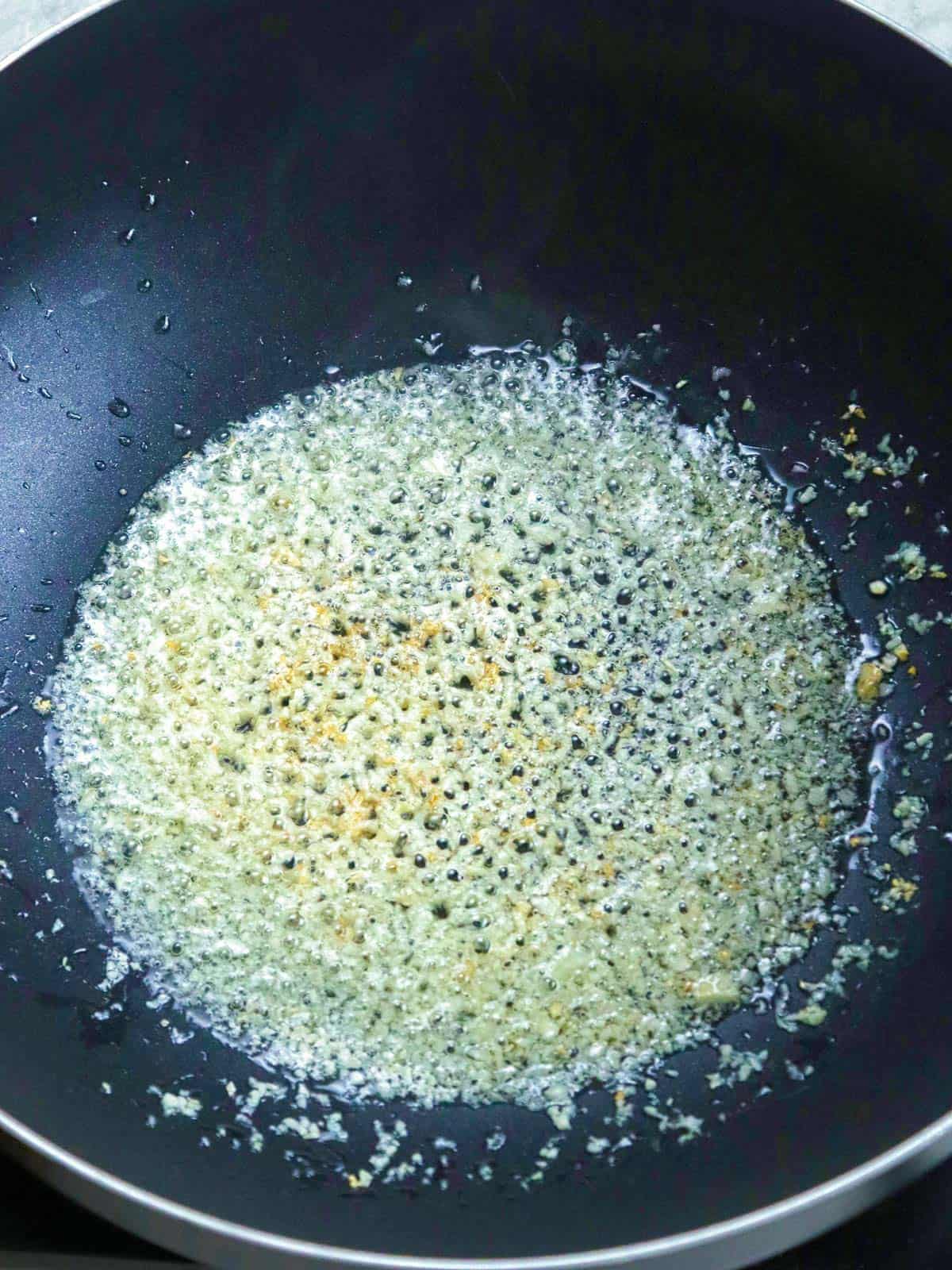 browning chopped garlic in oil in a pan