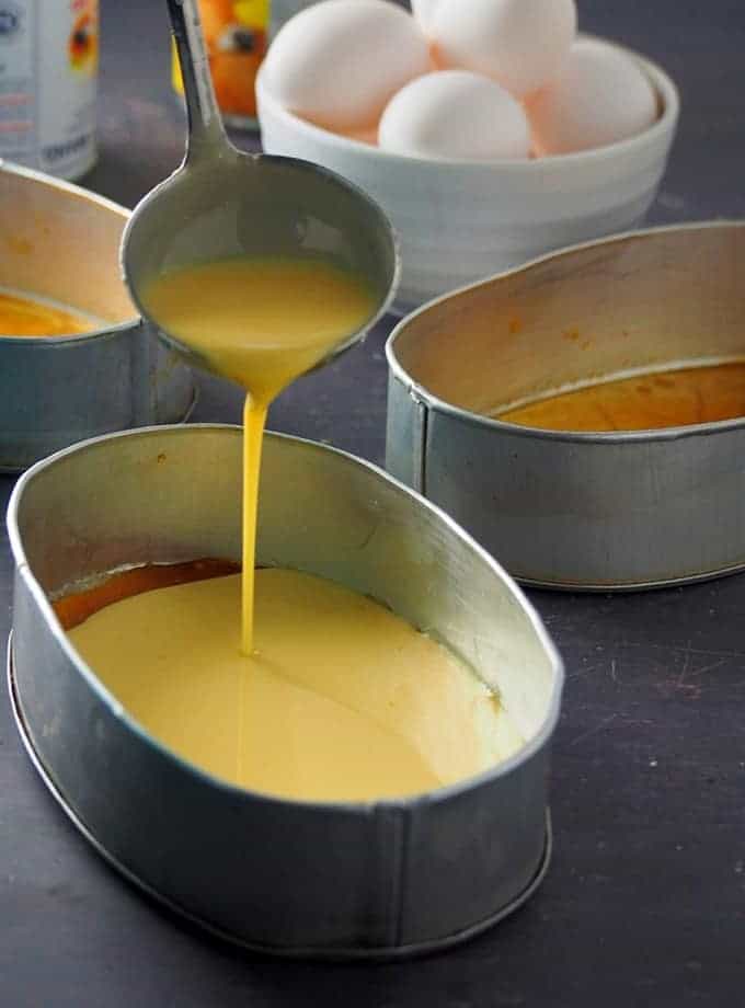 poruing leche flan mixture in a llanera